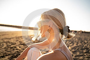 Beautiful blonde woman portrait in sunset on the beach. Profile. Relax