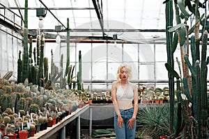 Beautiful blonde woman posing in tropical botanical garden