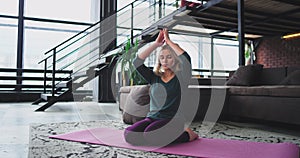 Beautiful blonde woman practicing yoga at home in the morning she stretching the body and have a healthy lifestyle