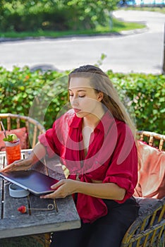 Beautiful blonde woman preparing her electronical tablet for a remote work