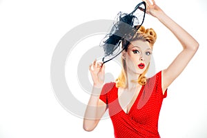 Beautiful blonde woman in red dress with retro hairstyle. Happy girl with hat. Perfect makeup and hairstyle. Smiling