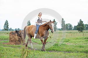 Beautiful blonde woman riding horse bareback