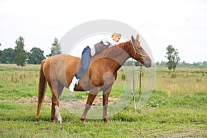 Beautiful blonde woman riding horse bareback