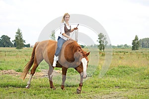 Beautiful blonde woman riding horse bareback