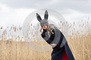 Beautiful blonde woman with scared face in black bunny mask