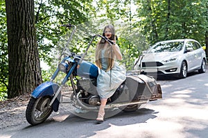 A beautiful blonde woman sitting on a motorcycle