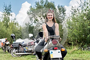 A beautiful blonde woman sitting on a motorcycle