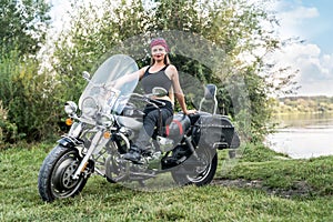 A beautiful blonde woman sitting on a motorcycle