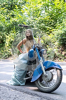 A beautiful blonde woman sitting on a motorcycle