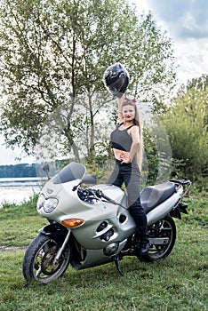 A beautiful blonde woman sitting on a motorcycle