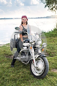 A beautiful blonde woman sitting on a motorcycle