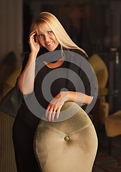 Beautiful Blonde Woman Standing Near Chair