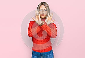 Beautiful blonde woman wearing casual clothes rejection expression crossing arms doing negative sign, angry face