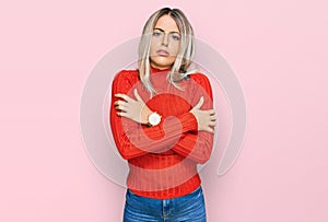 Beautiful blonde woman wearing casual clothes shaking and freezing for winter cold with sad and shock expression on face