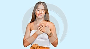 Beautiful blonde woman wearing casual clothes smiling with hands on chest with closed eyes and grateful gesture on face