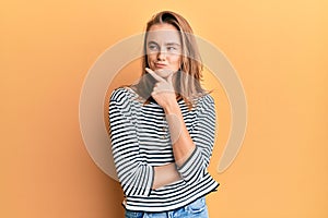 Beautiful blonde woman wearing casual clothes thinking concentrated about doubt with finger on chin and looking up wondering