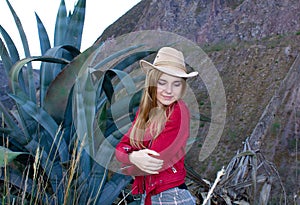 Beautiful blonde woman wearing a hat outdoors on a prairie