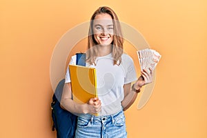 Beautiful blonde woman wearing student backpack and holding 50 turkish lira smiling with a happy and cool smile on face