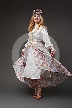 Beautiful blonde woman in white folklore costume