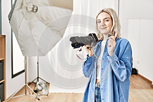 Beautiful blonde woman working as professional photographer at photography studio