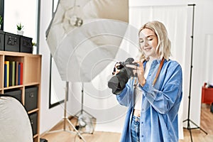 Beautiful blonde woman working as professional photographer at photography studio