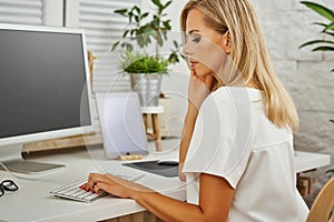 Beautiful blonde woman working on the computer
