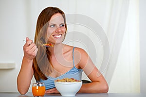 Beautiful blonde young woman eating breakfast