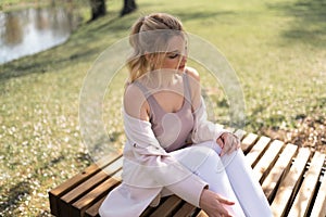 Beautiful blonde young woman in Sakura Cherry Blossom park in Spring enjoying nature and free time during her traveling