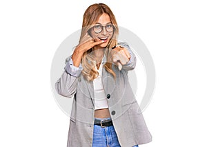 Beautiful blonde young woman wearing business clothes smiling doing talking on the telephone gesture and pointing to you