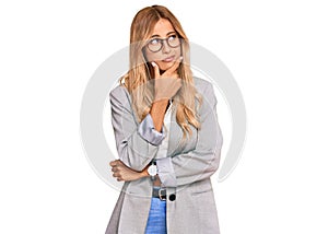 Beautiful blonde young woman wearing business clothes thinking worried about a question, concerned and nervous with hand on chin