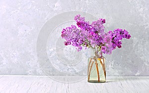 Beautiful blooming lilac branches in the glass jar on the table