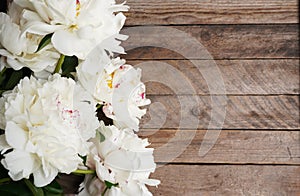 Beautiful blooming white peonies on a wooden background with a copy space