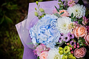 Beautiful blossoming flower bouquet of fresh hydrangea, roses, eustoma, mattiola, flowers in blue, pink and white colors