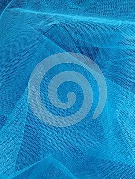 Beautiful blue background of transparent veil with several layers that create depth, airiness. Creative sky blue backdrop