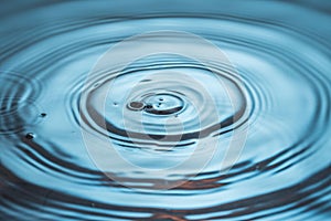 Beautiful blue backgrounds . Diverging circles on water surface from water drop