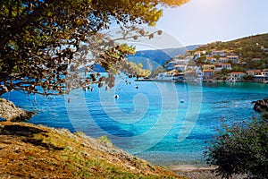 Beautiful blue bay surrounded by pine trees in Assos village located on Kefalonia. Summer tourism vacation trip around photo