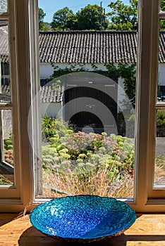 Beautiful blue bowl sits in a farmhouse window.