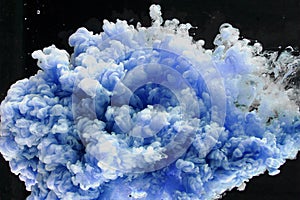 Beautiful blue cloud of paint in water, abstract colored background