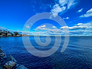 Beautiful blue and cloudy sky over a calm ocean.