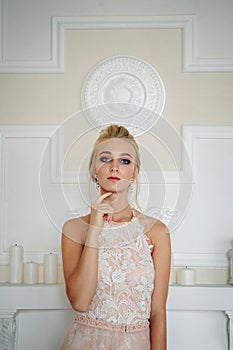 A beautiful blue-eyed blonde with a pensive face touches her face