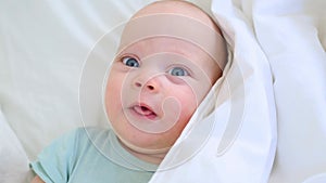 beautiful blue eyed infant baby portrait close-up, smiling face of little child