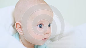 beautiful blue eyed infant baby portrait close-up, smiling face of little child