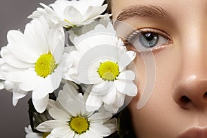 Beautiful blue female eye with white spring flower. Clean skin, fashion naturel make-up. Good vision, healthcare