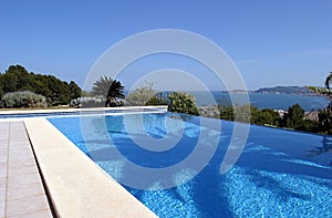 Beautiful blue fresh infinity swimming pool in a villa in sunny Spain with sea views