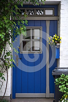 Beautiful blue front door with windows in a white painted brick