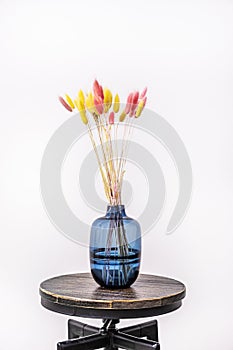 Beautiful blue glass vase with decorative dried plant branches for decoration