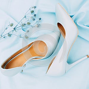 Beautiful blue high heel shoes. Flat lay, top view on blue background. Beauty blog concept. Pale blue female shoes.