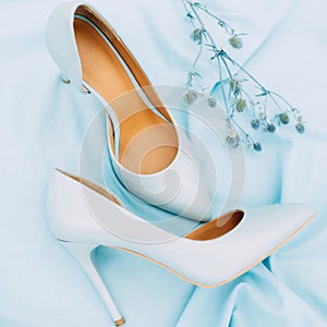 Beautiful blue high heel shoes. Flat lay, top view on blue background. Beauty blog concept. Pale blue female shoes. Blue wedding.