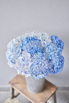 Beautiful blue hydrangea flowers in a vase on a table . Bouquet of light pink flower. Decoration of home. Wallpaper and