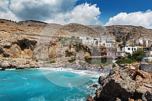 Beautiful blue lagoon with umbrellas at sandy beach, Chora Sfakion town, Crete island